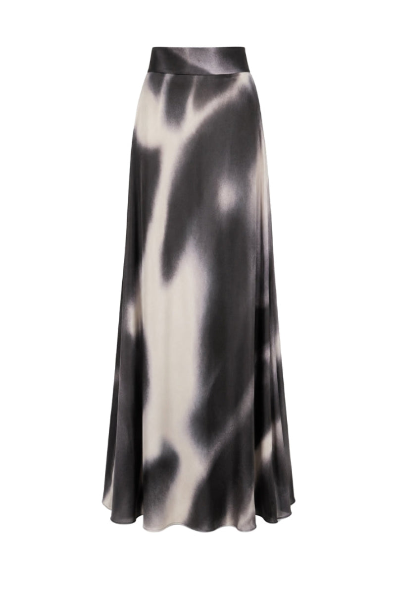 Black printed Tinta Latina Miel maxi skirt with flowing fabric and elastic waistband, displayed on a hanger.