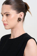 A model wearing gold Lush earrings by Aidan & Ice, showcasing elegant gold earrings with a sleek, polished finish.