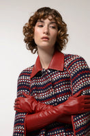 Brushed red wool cape coat by Lalo displayed on a hanger, showcasing its textured fabric and classic design.