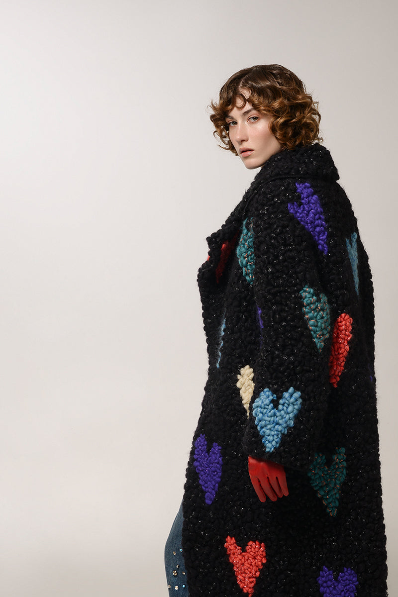 Lalo black hearts wool coat with a tailored fit, featuring a classic collar and button closure, displayed on a hanger.