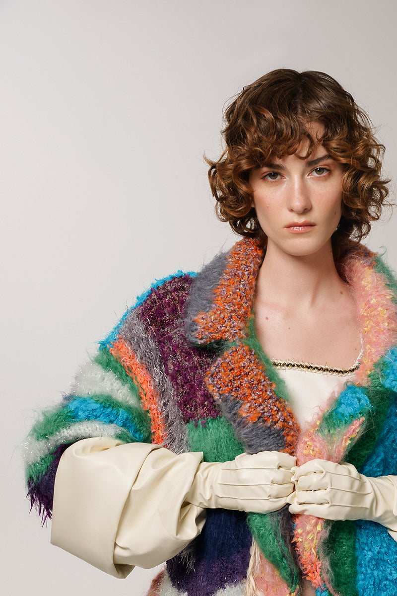 Lalo Peach Landscape Mohair Coat hanging on a coat rack, showcasing its soft, textured fabric and stylish design.