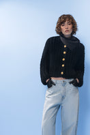 Black cable knit wool cardigan by Lalo, featuring a cozy textured design and button closure.