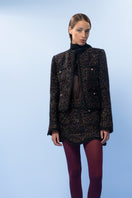 Lalo brown checkerered wool mini skirt displayed on a hanger, showing its pattern and fabric texture.