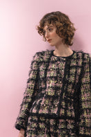 Black textured wool mini skirt from Lalo, showing the fitted waist and A-line silhouette with detailed fabric texture.