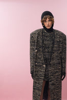 Lalo gold and black wool coat displayed on a hanger, showcasing its stylish design and luxurious fabric.