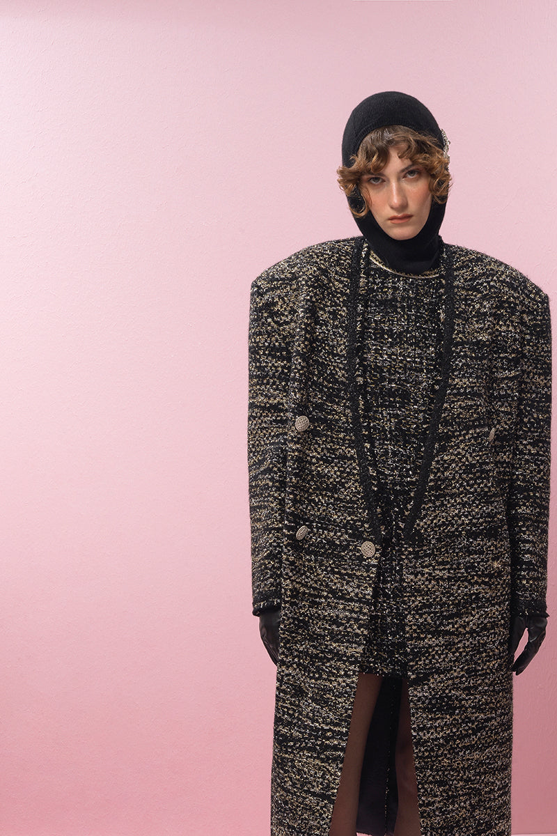 Lalo gold and black wool coat displayed on a hanger, showcasing its stylish design and luxurious fabric.