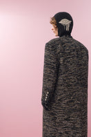 Lalo gold and black wool coat displayed on a hanger, showcasing its stylish design and luxurious fabric.