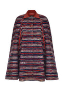 Lalo brushed red wool cape coat hanging on a display rack, showcasing its elegant design and textured fabric.