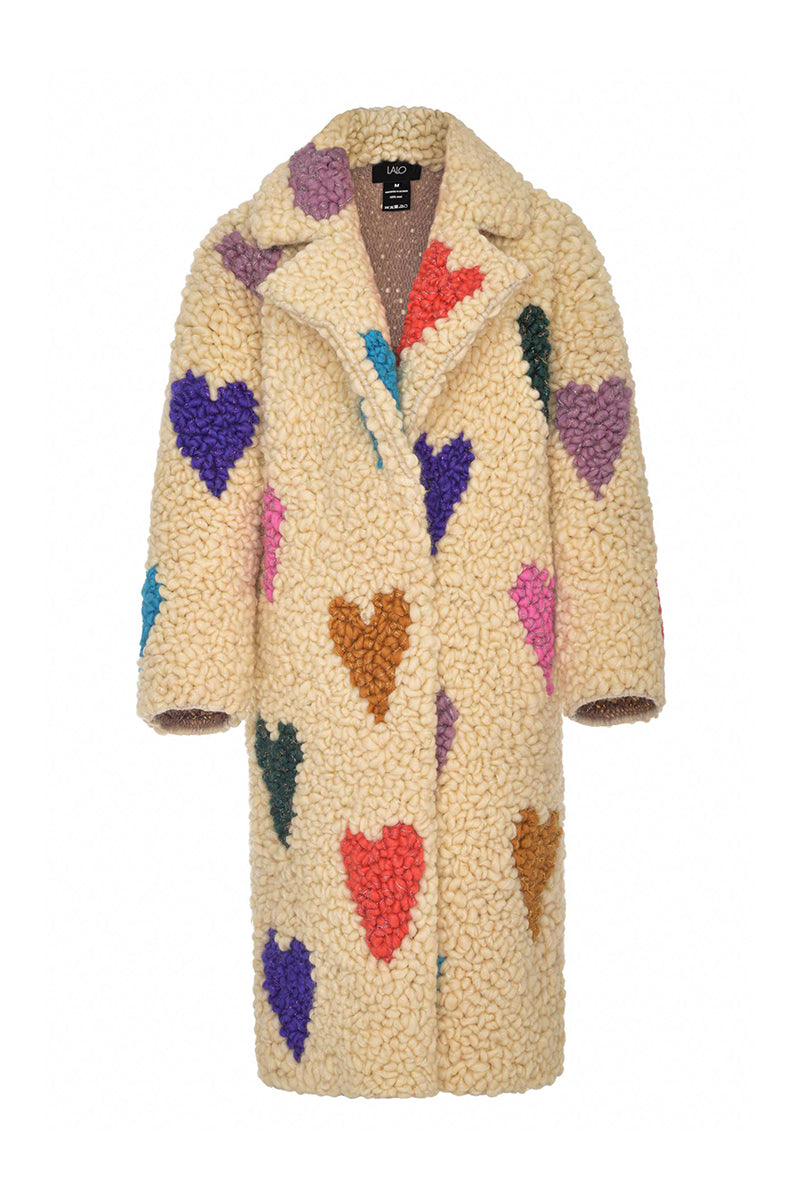 Lalo cream hearts wool coat hanging on a wooden hanger, showcasing its soft fabric and classic design.