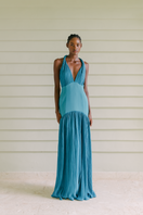 Maylé Vásquez Cayo Turquoise Maxi Dress featuring flowing fabric and a stylish neckline, perfect for elegant summer occasions.