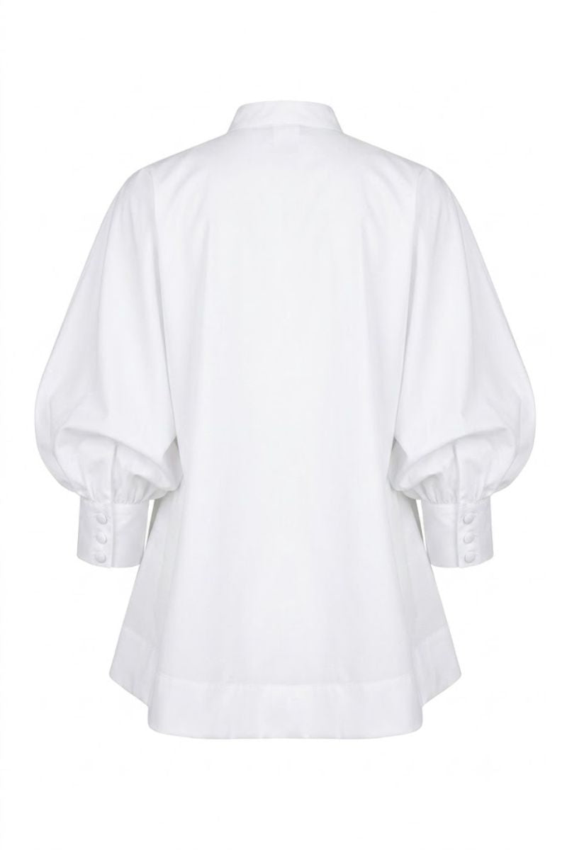 White FIORA top by ANA + MARIA displayed on a mannequin, featuring a stylish and elegant blouse with a soft, flowing fabric.