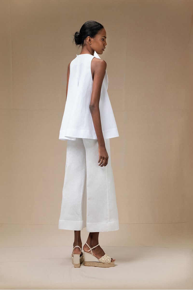 White Magnolia blouse by ANA + MARIA, featuring lightweight fabric and classic design, shown on a hanger.