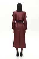 Vegan leather maxi trench coat with buckles in burgundy by Kris Marán, shown from the back showing its length and stylish design.