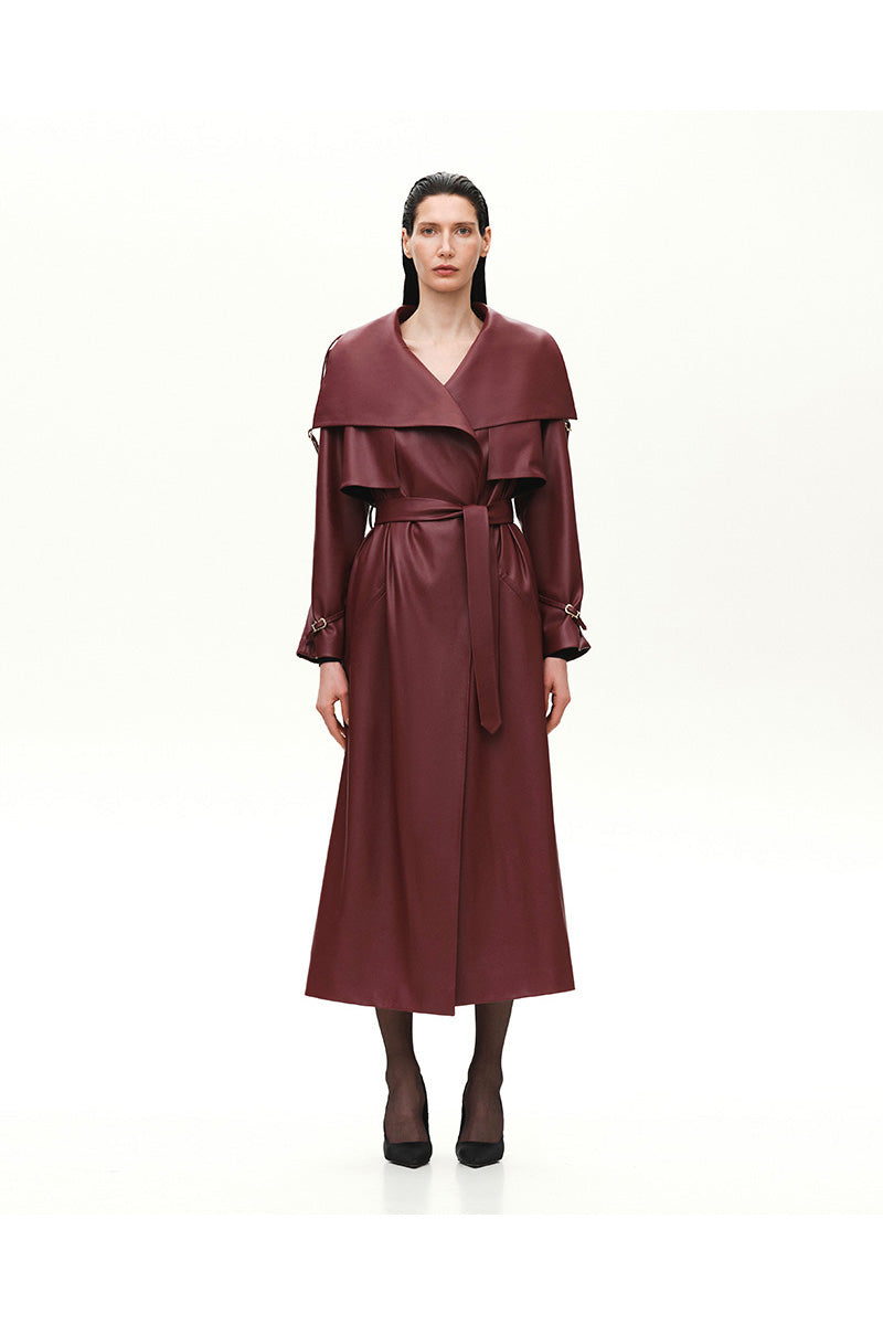Kris Marán vegan leather maxi trench coat in burgundy with buckle details, featuring a long, stylish coat design.