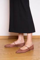 A pair of AERA Maya Paprika intrecciato flats with woven design and pointed toes, shown from a side angle on a white background.