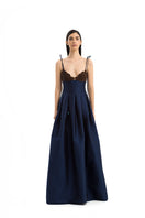 Elegant brown and navy gown by Maylé Vásquez, featuring a flowing design and intricate detailing.