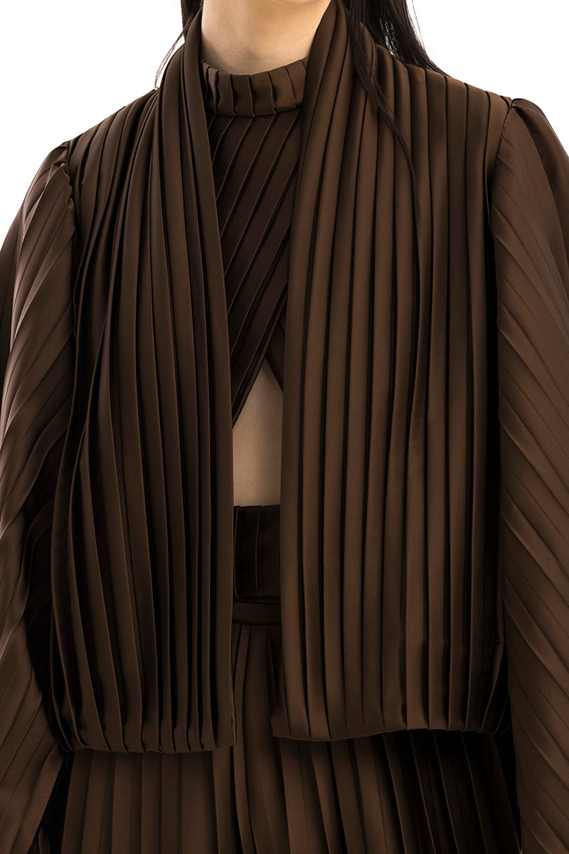 Brown COSTE NORTA jacket by Maylé Vásquez, shown on a hanger with front view and detailed fabric texture.