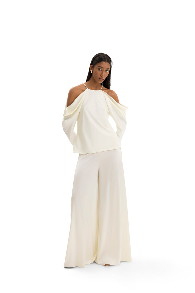 Maylé Vásquez Altagracia top featuring a stylish design, displayed on a model with a close-up view of the fabric and neckline.