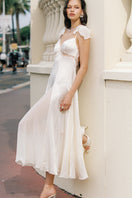 Nana Jacqueline Meadow Maxi Dress in champagne with open back, flowing fabric, perfect for elegant summer occasions.