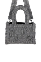 Medium Bani Poka Gardo top handle bag with sleek design and structured shape, showcased in a stylish photoshoot.
