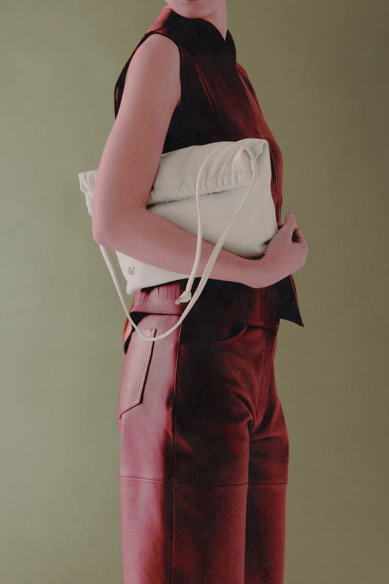 White Melissa clutch leather bag by Double A featuring a sleek, minimalist design with a fold-over flap and subtle branding.