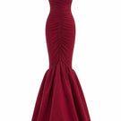 Red Mencia gown by Maylé Vásquez from the CULT MIA X MALYÉ VÁSQUEZ collection, shown on a model with flowing fabric.