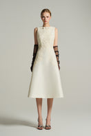 Ivory sleeveless knee-length midi dress by I.H.F Studio with lace fabric and a crystal-embellished bow detail.
