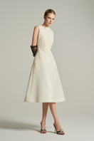 Ivory sleeveless knee-length midi dress by I.H.F Studio with lace details and crystal-embellished bow at the waist.