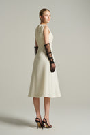 Ivory sleeveless knee-length midi dress by I.H.F Studio with lace fabric and crystal-embellished bow detail.
