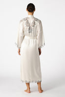 Elegant ivory silk bridal robe by NK IMODE, featuring long, flowing design with delicate lace trim and intricate detailing.