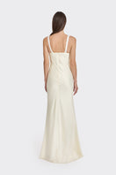 Light yellow Stolen Stores mini bow maxi dress displayed on a hanger, showcasing its flowing fabric and elegant design.