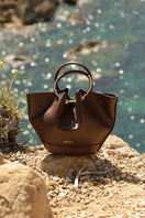 Mini Capazo chocolate leather top handle bag by Saonara with a structured design and sleek finish.