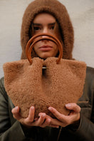 Saonara Mini Capazo Cozy top handle bag in caramel color, showcasing its compact design and soft leather texture.