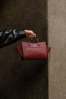 Saonara mini shopping shoulder bag in berry leather with top handle and adjustable strap, stylish and compact for everyday use.
