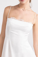 White Nana Jacqueline Mirabelle satin maxi dress displayed on a model, showcasing elegant midi dress design and flowing fabric.