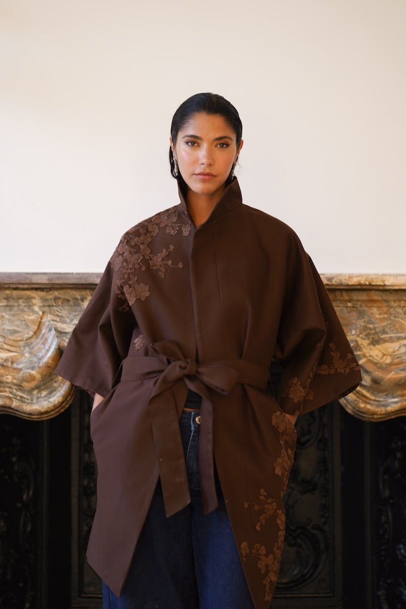 Nadya Shah mocha rose detail coat displayed on a hanger, showcasing its elegant fabric and intricate design.