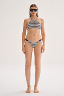 Nelblu GINNI bikini bottom in blue print with high-cut design, worn by a model on the beach.