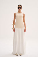 Model wearing Nelblu beige Liz maxi dress with flowing fabric and sleeveless design, styled for casual or semi-formal occasions.