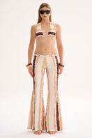 Nelblu Jagger printed orange cover-up pants worn by a model, featuring vibrant print and relaxed fit for beach or poolside wear.