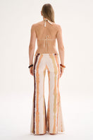 Nelblu Jagger print orange cover-up pants worn by model, lightweight fabric with vibrant orange and patterned design.