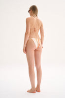 Nelblu SOL bikini bottom with full coverage in vibrant orange printed fabric, shown on a model.