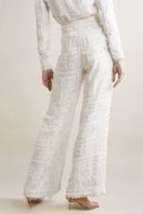 Model wearing white SemSem silk chiffon wide leg pants, back view showing flowing fabric and embellished waistband.