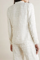 SemSem white silk chiffon embellished blouse worn by model, showing back view with intricate embellishments and flowing fabric.