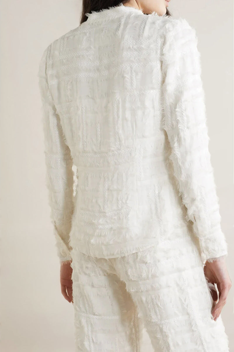 SemSem white silk chiffon embellished blouse worn by model, showing back view with intricate embellishments and flowing fabric.