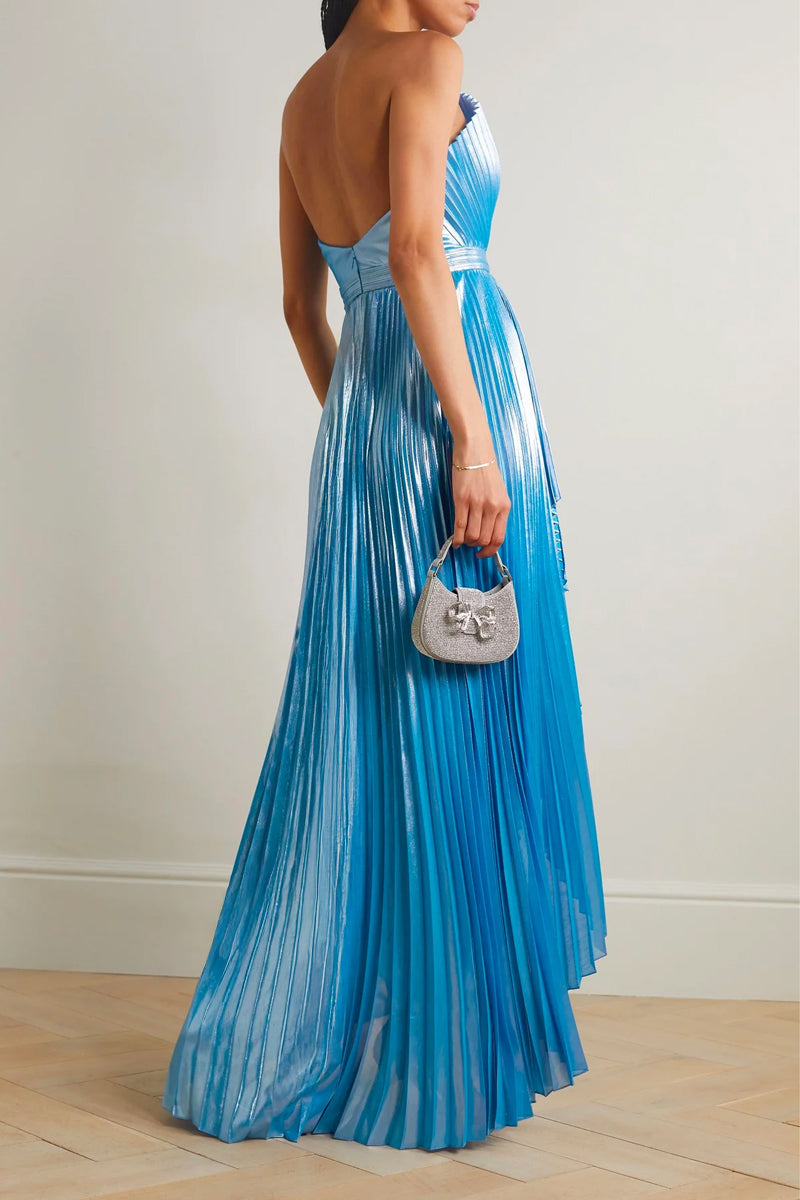 Model wearing a blue SemSem Capri draped plissé lamé maxi gown, back view showcasing flowing fabric and elegant design.