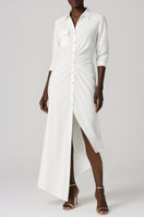 Model wearing SemSem white Egyptian cotton maxi dress with an asymmetric design, front view showcasing flowy fabric and elegant style.