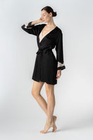 NK IMODE CULT MIA X NK IMODE Morgan short robe in black, shown in a side profile view highlighting its relaxed fit and soft fabric.
