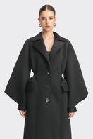 Black coat from Stolen Stores MS. DOLL collection, stylish outerwear displayed on a hanger with a sleek design.
