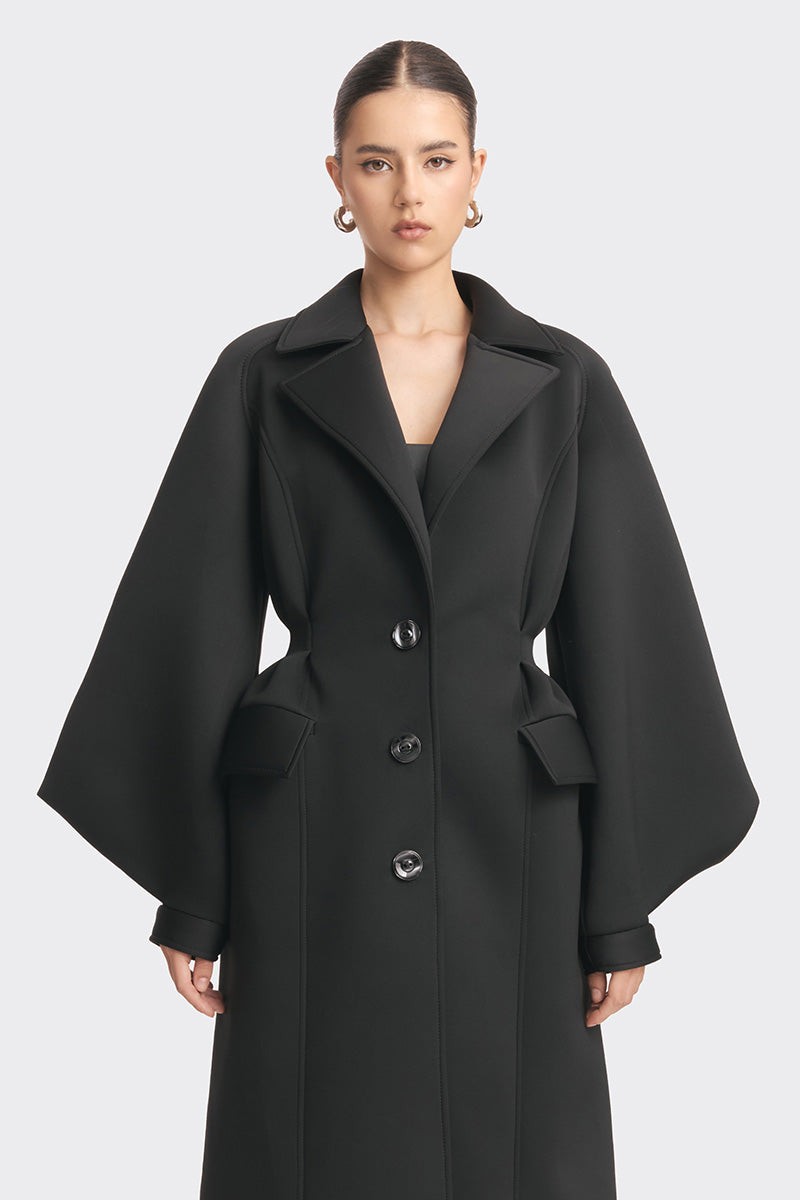 Black coat from Stolen Stores MS. DOLL collection, stylish outerwear displayed on a hanger with a sleek design.