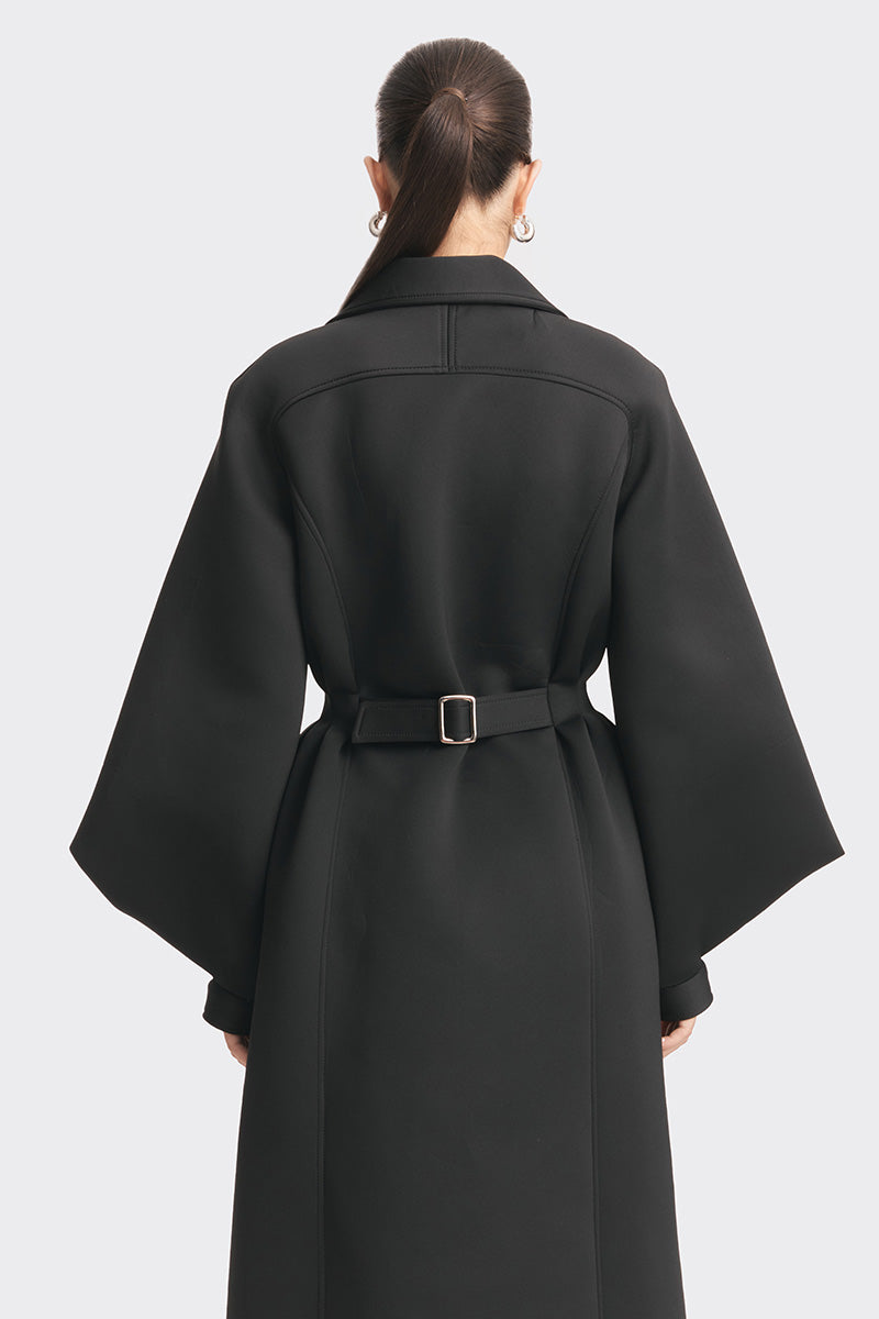 Black MS. Doll coat from Stolen Stores displayed on a model, showcasing a stylish, modern coat with sleek design and tailored fit.